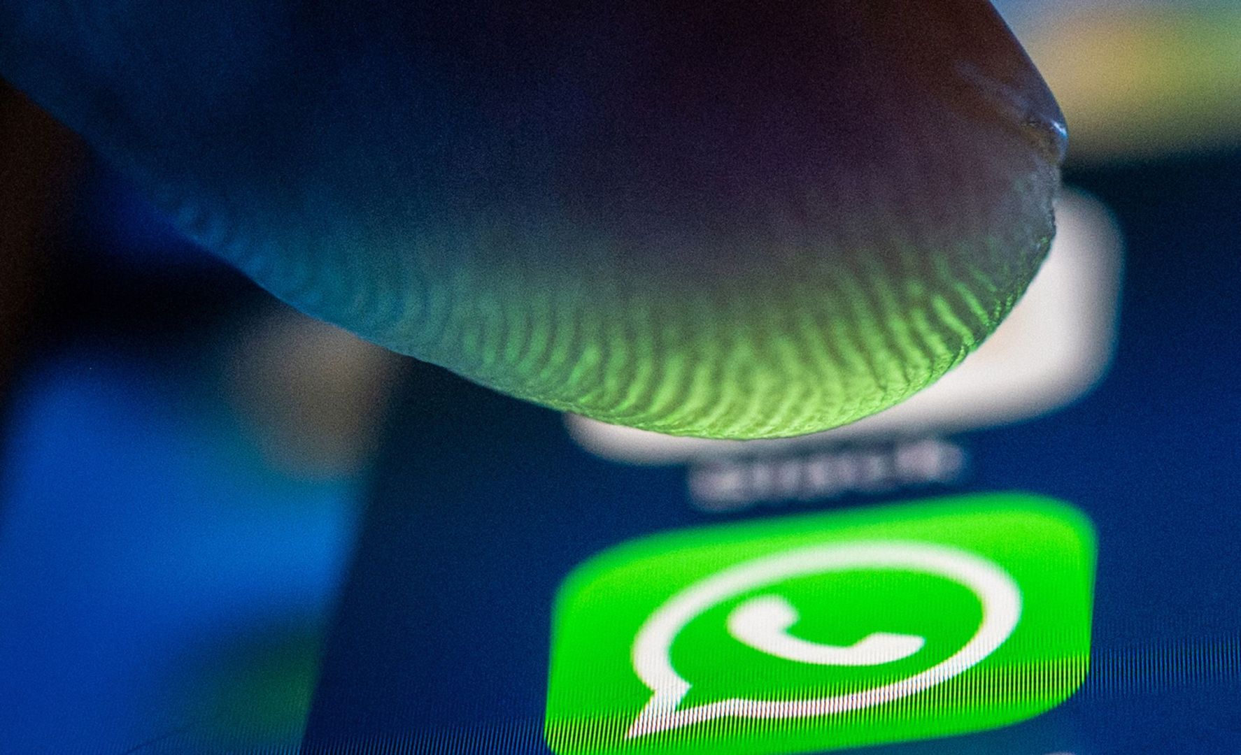 Ein Finger über dem Whatsapp Symbol