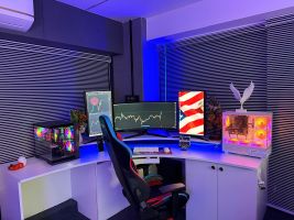 Ein Hightech-Gaming- und Aktienhandels-Setup mit RGB-Beleuchtung, drei Monitoren und Gaming-Stuhl.