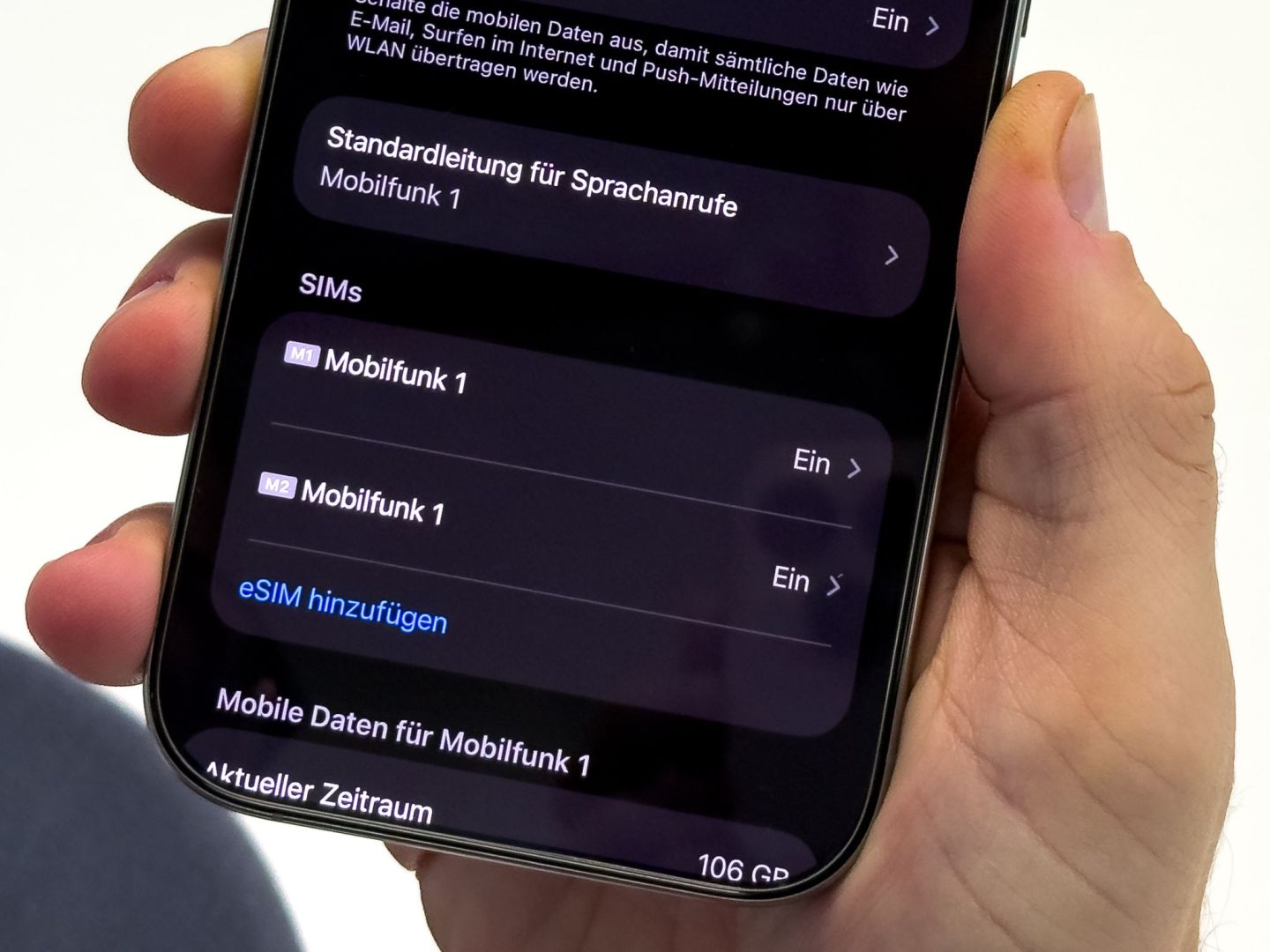 Ein Mann aendert die SIM-Karten-Einstellungen auf einem iPhone