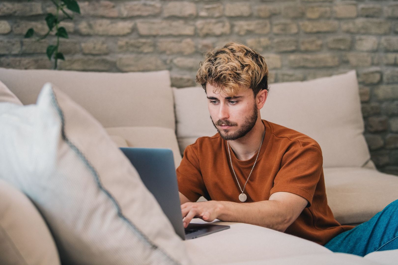 Ein Mann am Laptop auf einer Couch