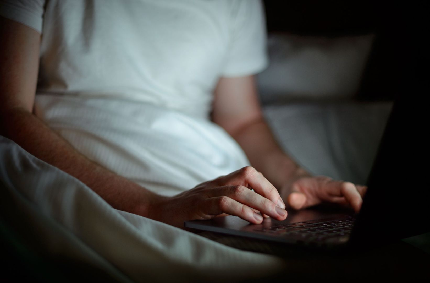 Ein Mann arbeitet im Batt am Laptop