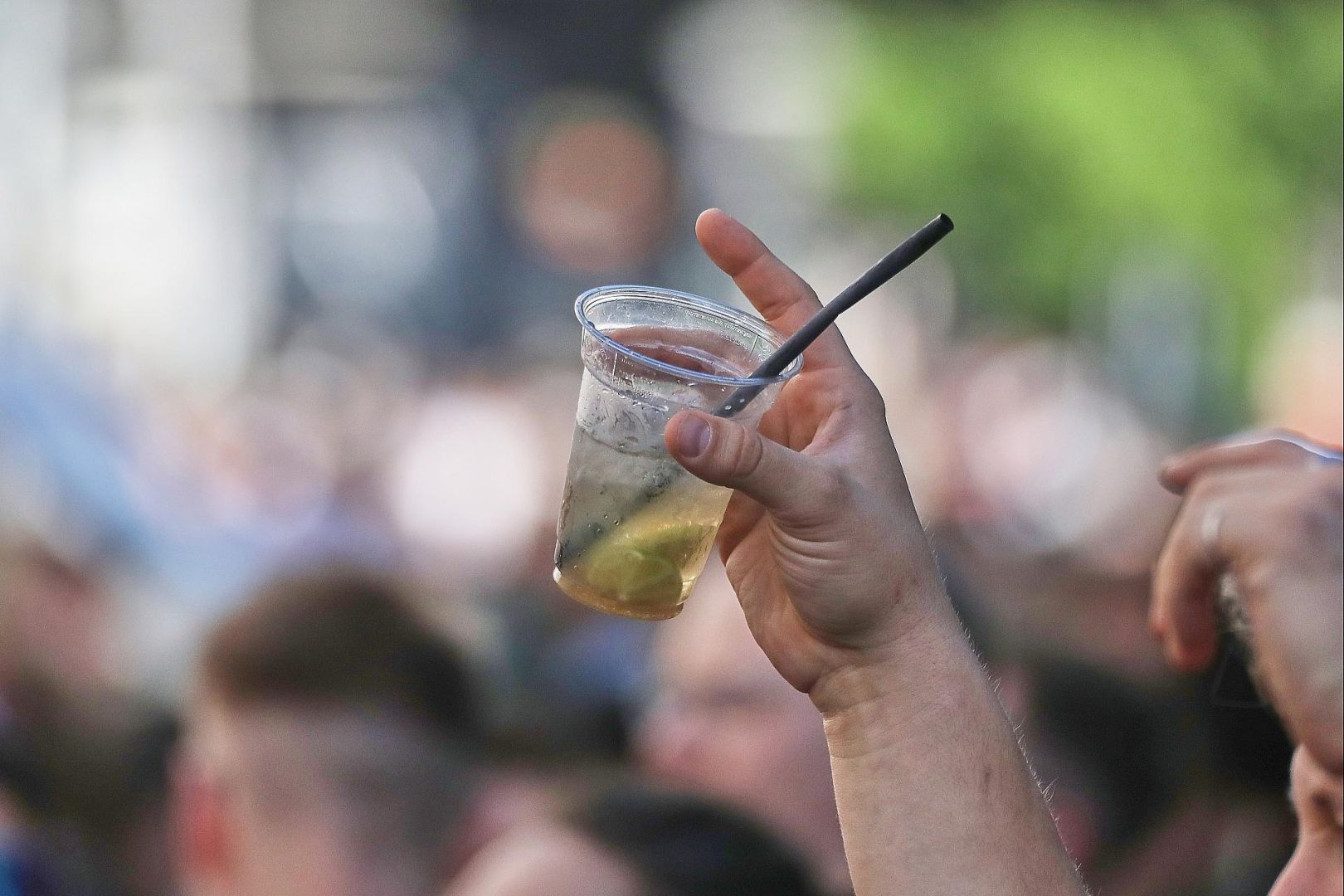 Ein Mann hält ein alkoholisches Getränk hoch (Archiv)