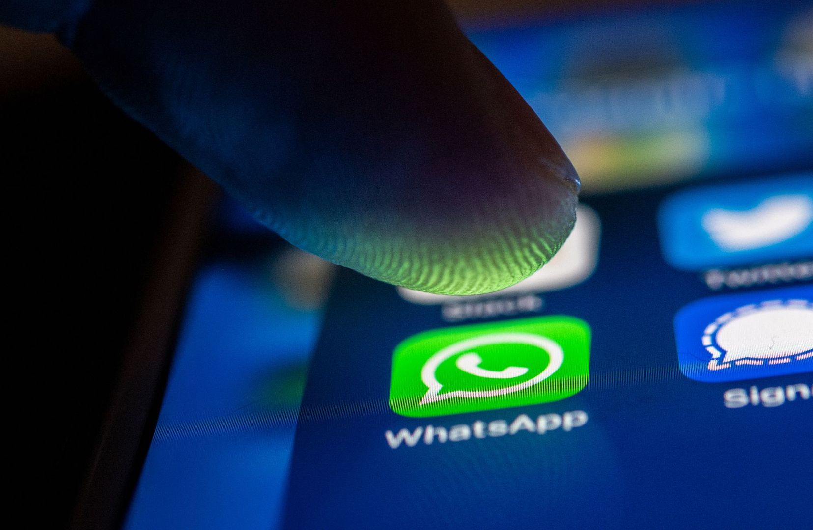 Ein Mann öffnet WhatsApp auf einem Smartphone