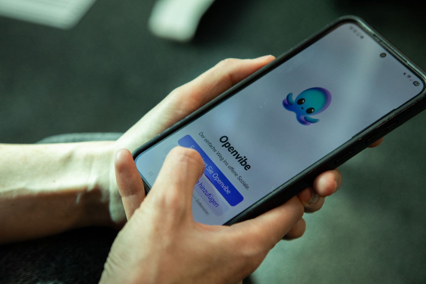 Eine Frau nutzt die App Openvibe auf dem Smartphone