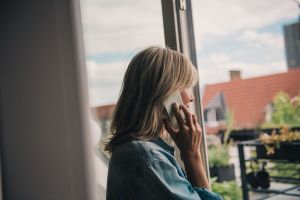 Eine Frau telefoniert am Fenster