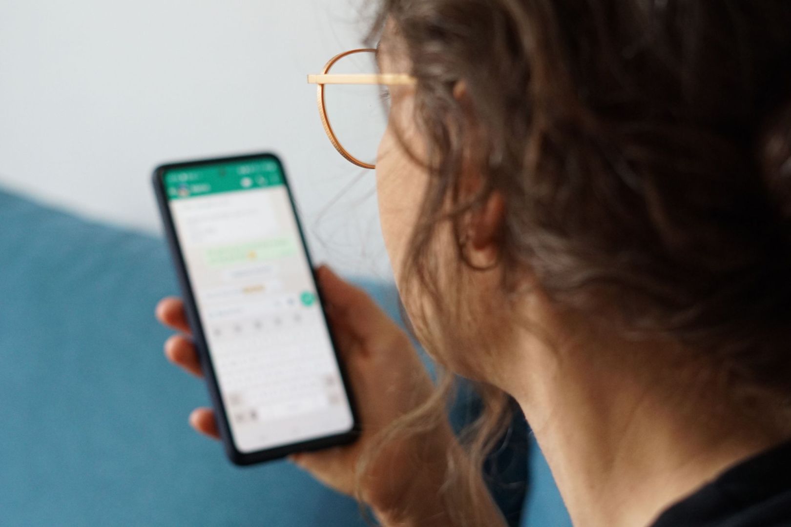 Eine junge Frau liest eine Nachricht auf einem Smartphone