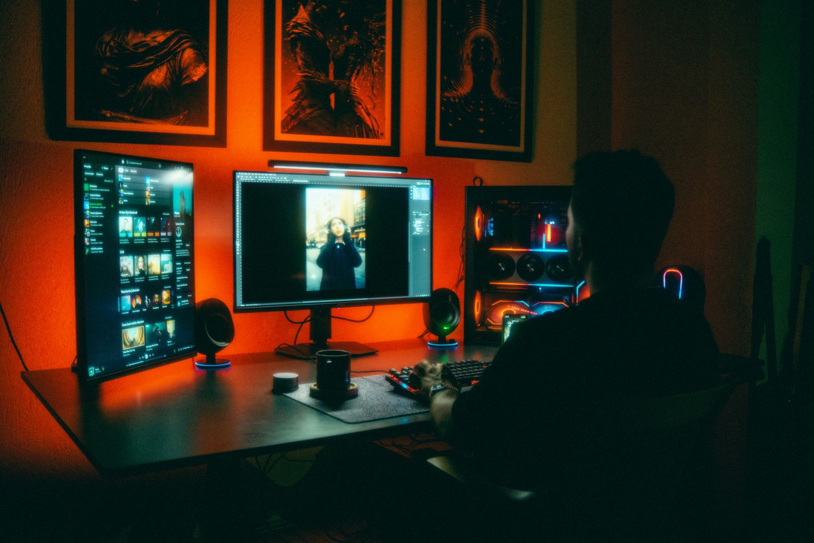 Eine Person bearbeitet nachts Fotos in einem neonbeleuchteten Heimbüro mit zwei Bildschirmen.
