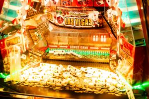 Farbenfroher Casino-Spielautomat mit Las Vegas-Thema, Münzen und Pokerkarten.