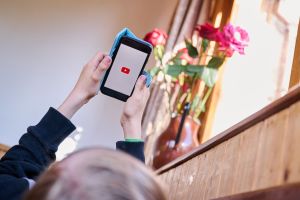 Junge öffnet auf seinem Smartphone die App von YouTube