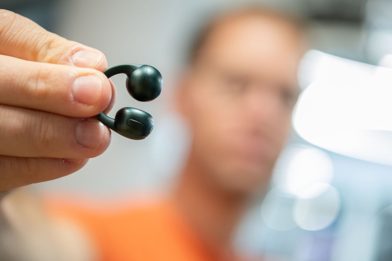 Mann hält die Moto Buds Loop von Motorola in der Hand