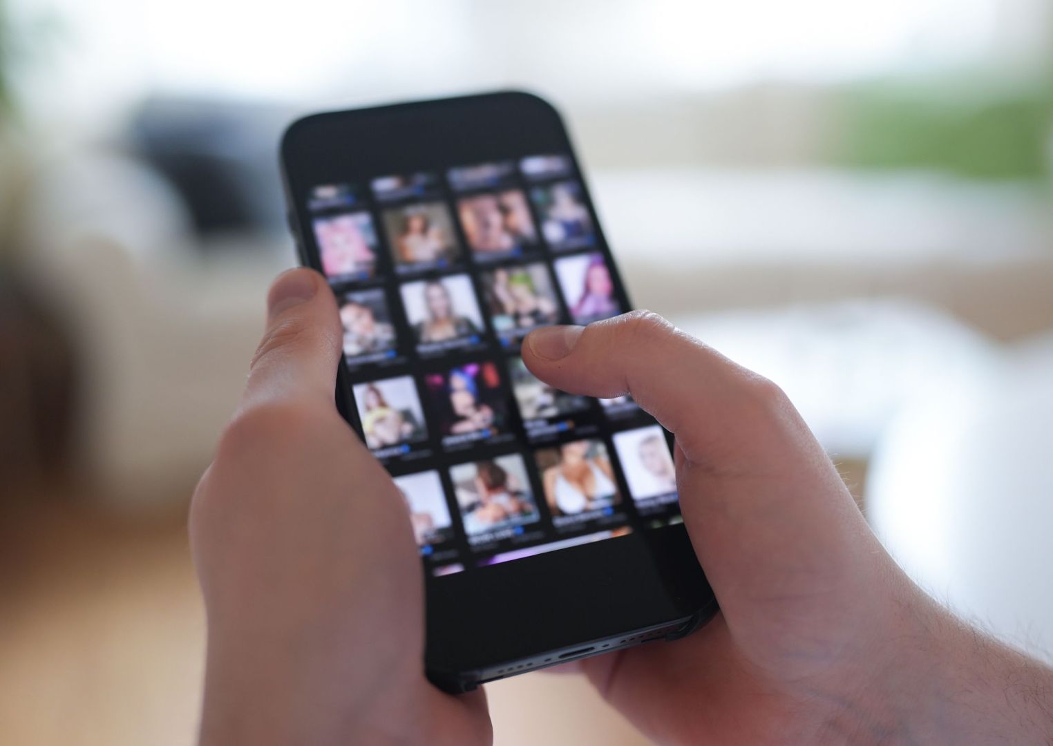 Mann schaut sich Videos auf einem Smartphone an