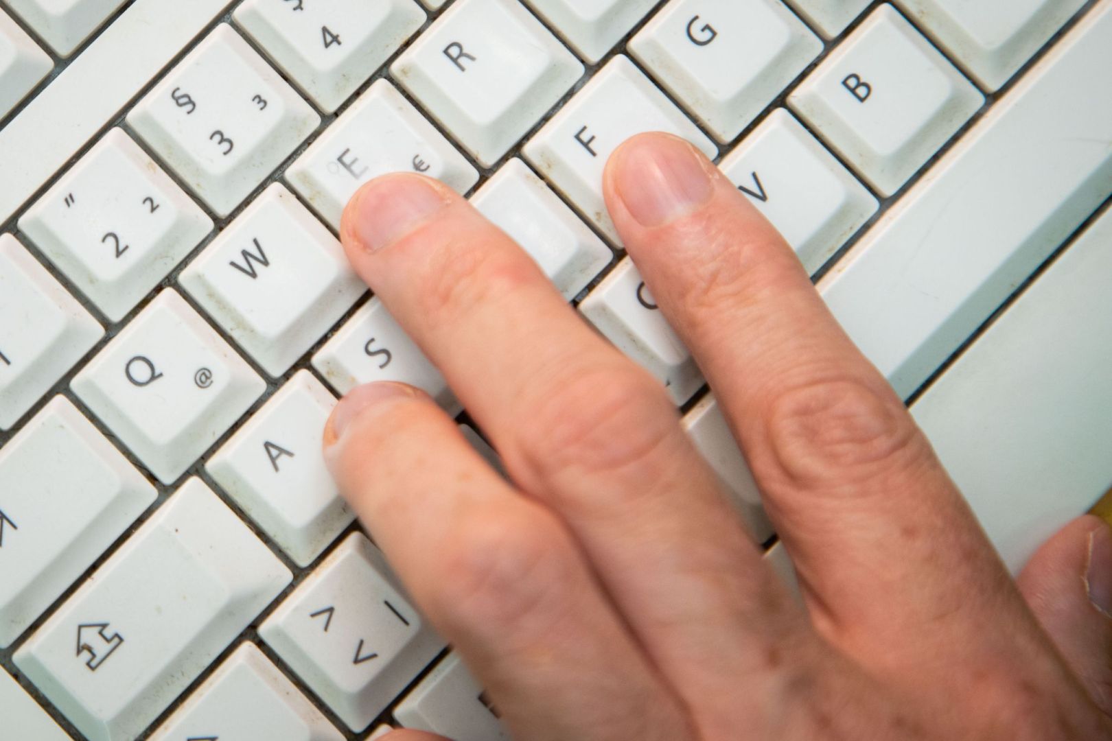 Mann tippt auf einer Tastatur