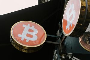 Nahaufnahme von Bitcoin-Symbolschildern im Freien, die moderne Kryptowährungstrends widerspiegeln.