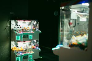 Schwach beleuchtete Spielhalle mit Greifautomaten und leuchtender Neonbeleuchtung, die moderne Freizeitgestaltung und Spielerlebnisse einfängt.