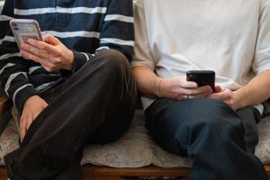  Zwei Männer halten ihre Smartphones in den Händen
