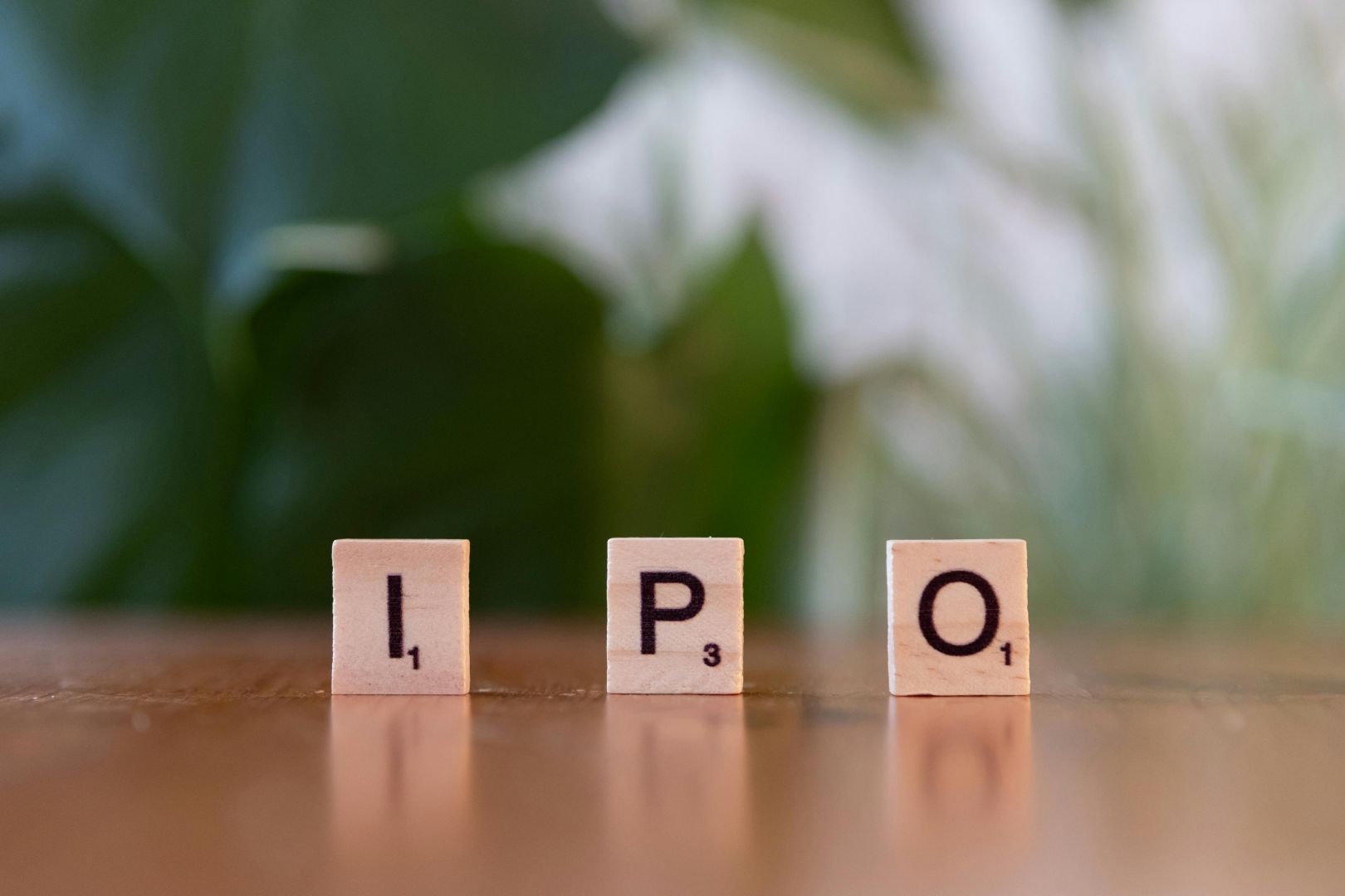 auf einem tisch stehen hölzerne buchstabenblöcke mit der aufschrift „ipo“, die investitionsmöglichkeiten symbolisieren.