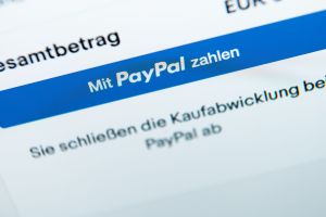 Der Schriftzug «Mit PayPal zahlen» auf einem Laptop