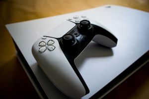 Detailaufnahme eines PlayStation 5-Controllers, der auf der Konsole liegt und das moderne Gaming-Design hervorhebt.
