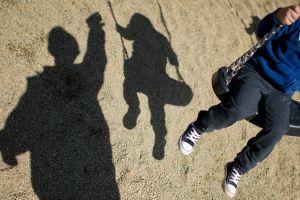 Ein Erwachsener schubst die Schaukel eines Kindes an