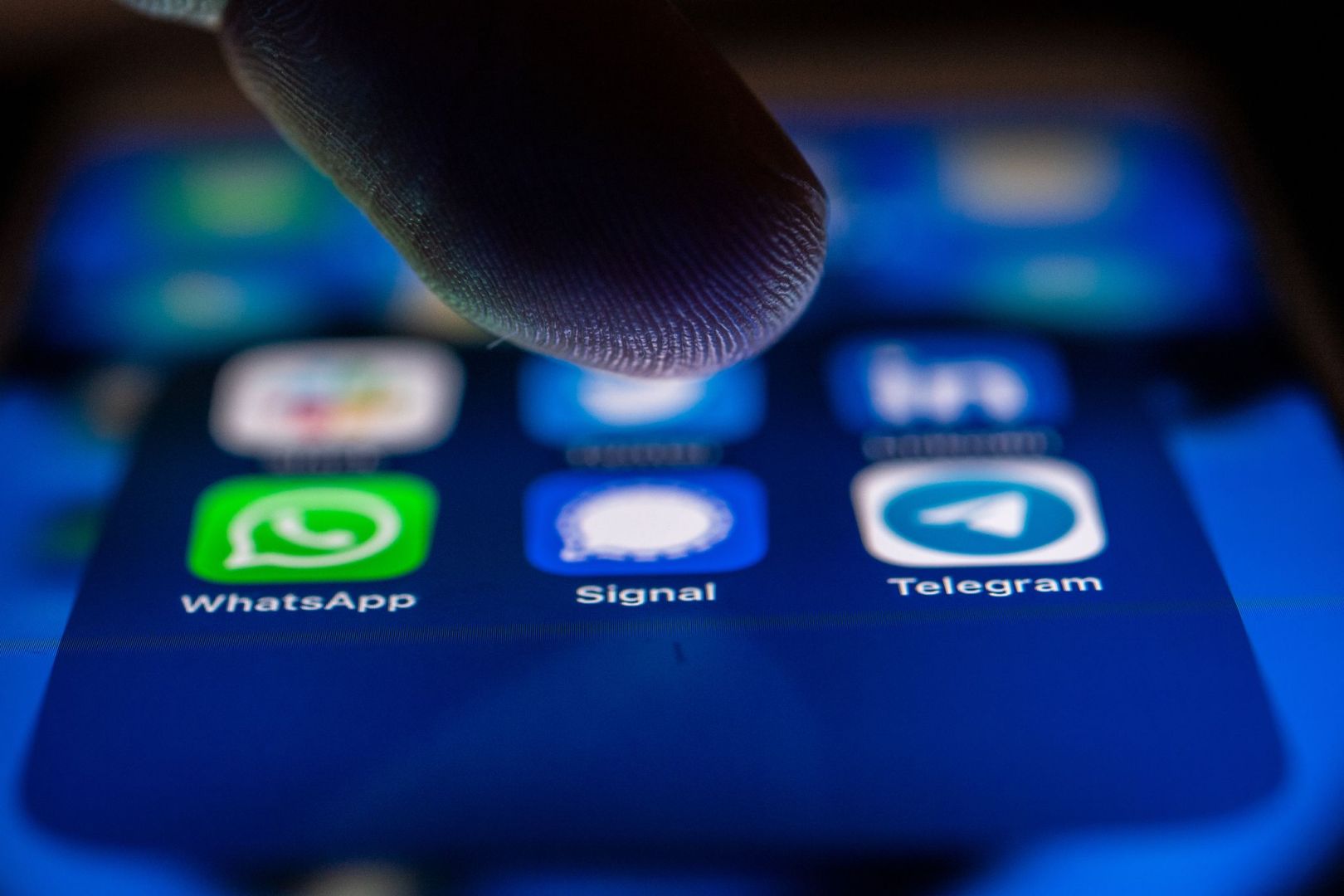 Ein Finger schwebt über dem Icon der Signal-App 