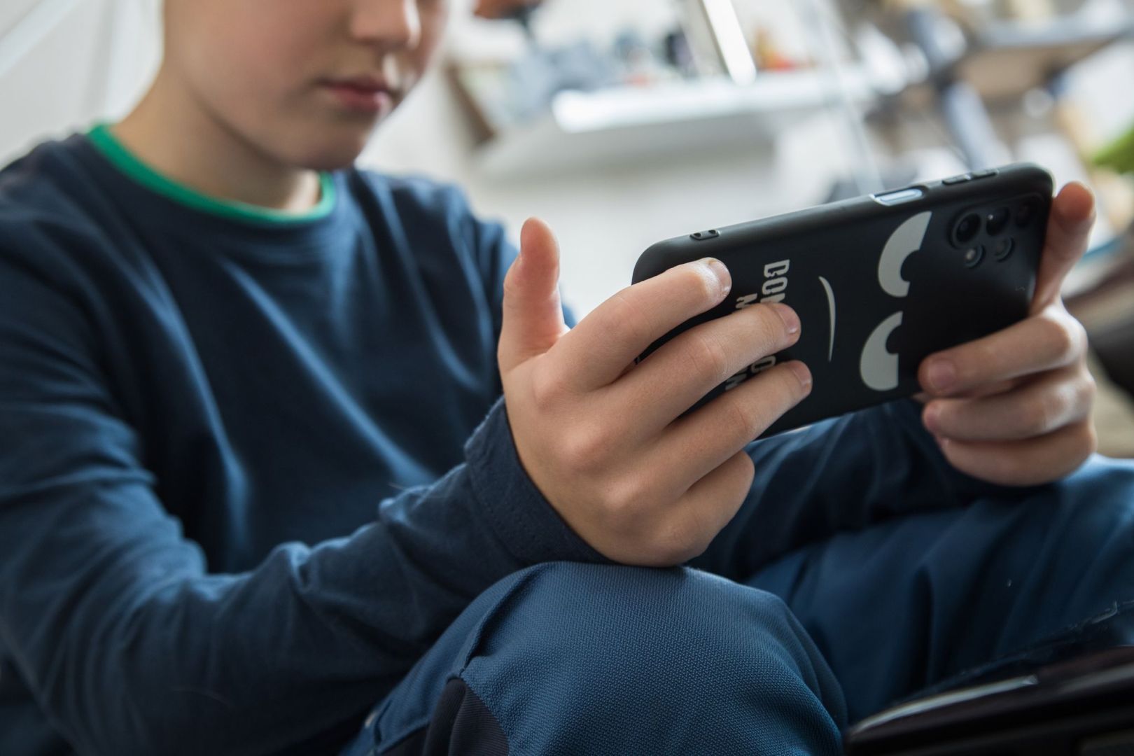 Ein Junge schaut auf sein Smartphone