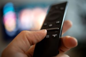 Ein Mann hält eine Fernbedienung mit der Aufschrift Amazon Prime