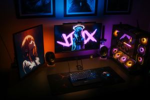Ein modernes Gaming-Setup mit RGB-Beleuchtung, zwei Monitoren und einem benutzerdefinierten PC mit farbenfrohen Komponenten.