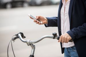 Eine Frau mit Smartphone und Fahrrad