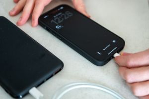 Eine Frau schließt ein iPhone an eine Powerbank an