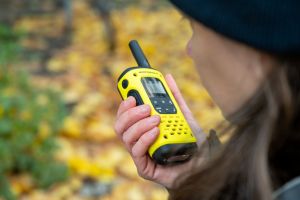 Eine Frau spricht in ein Walkie-Talkie in ihrer Hand