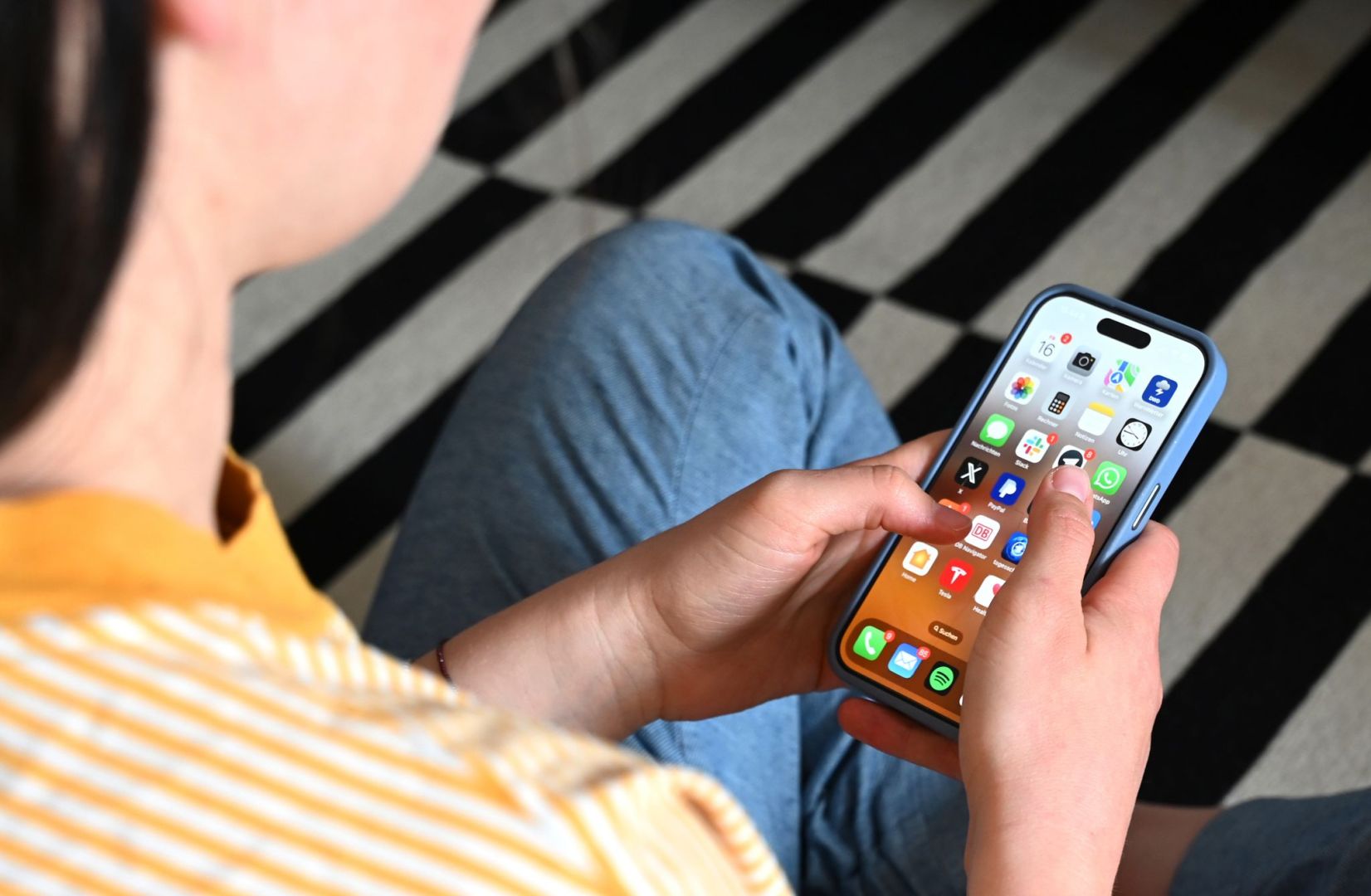 Eine Jugendliche sitzt am Smartphone (Archivbild)