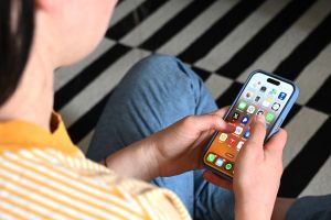 Eine Jugendliche sitzt am Smartphone (Archivbild)