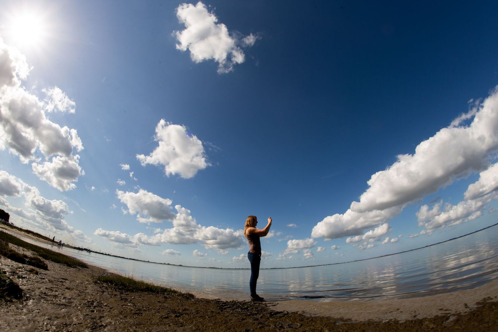 Frau fotografiert mit einem Smartphone die Landschaft