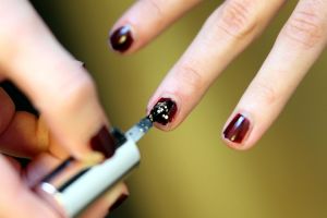 Frau lackiert Fingernägel mit Nagellack (Archiv)