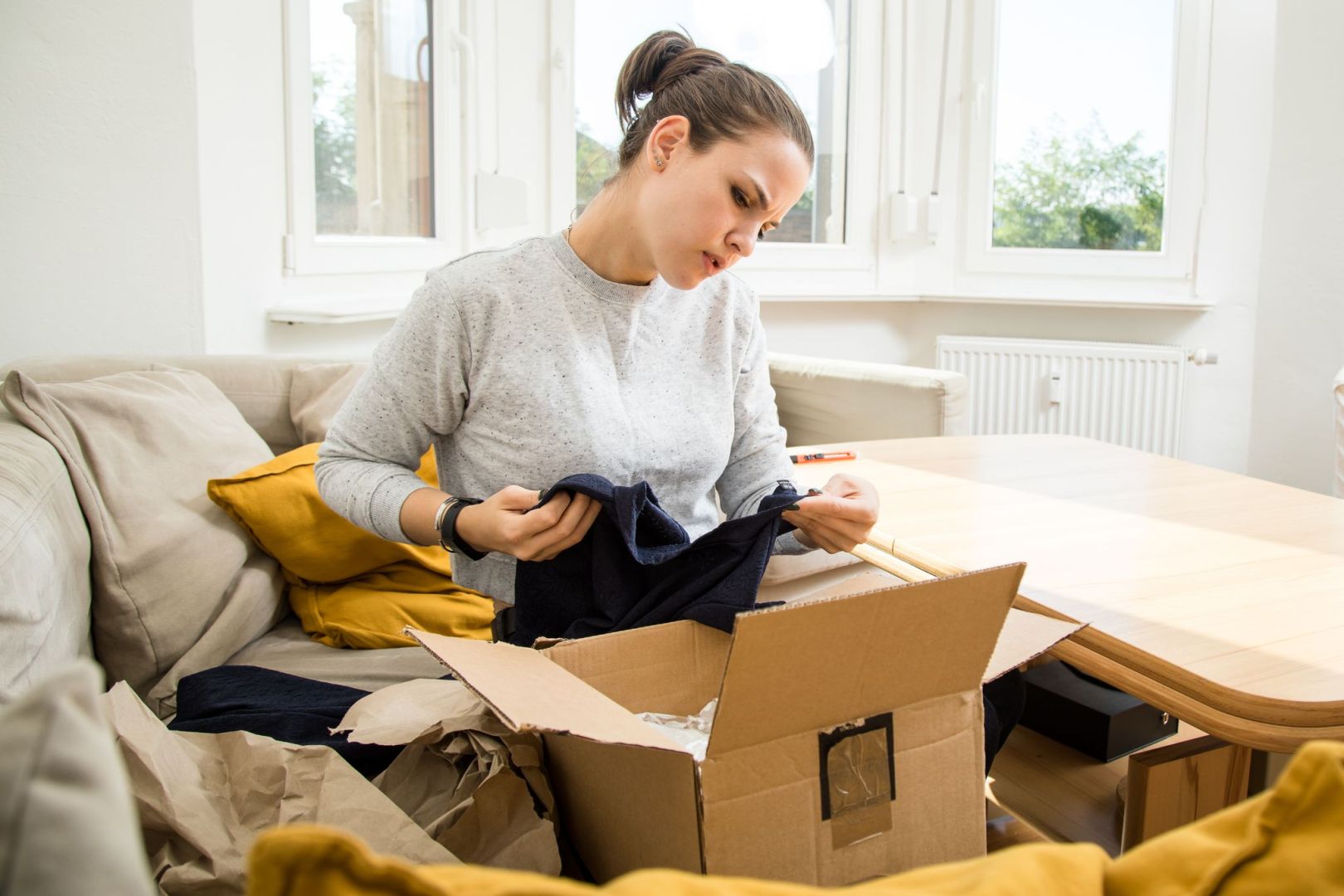 Frau prüft kritisch die Lieferung der online bestellten Ware