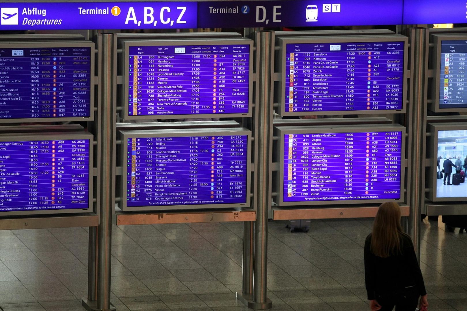 Frau vor Informationstafel am Frankfurter Flughafen