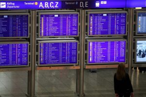 Frau vor Informationstafel am Frankfurter Flughafen