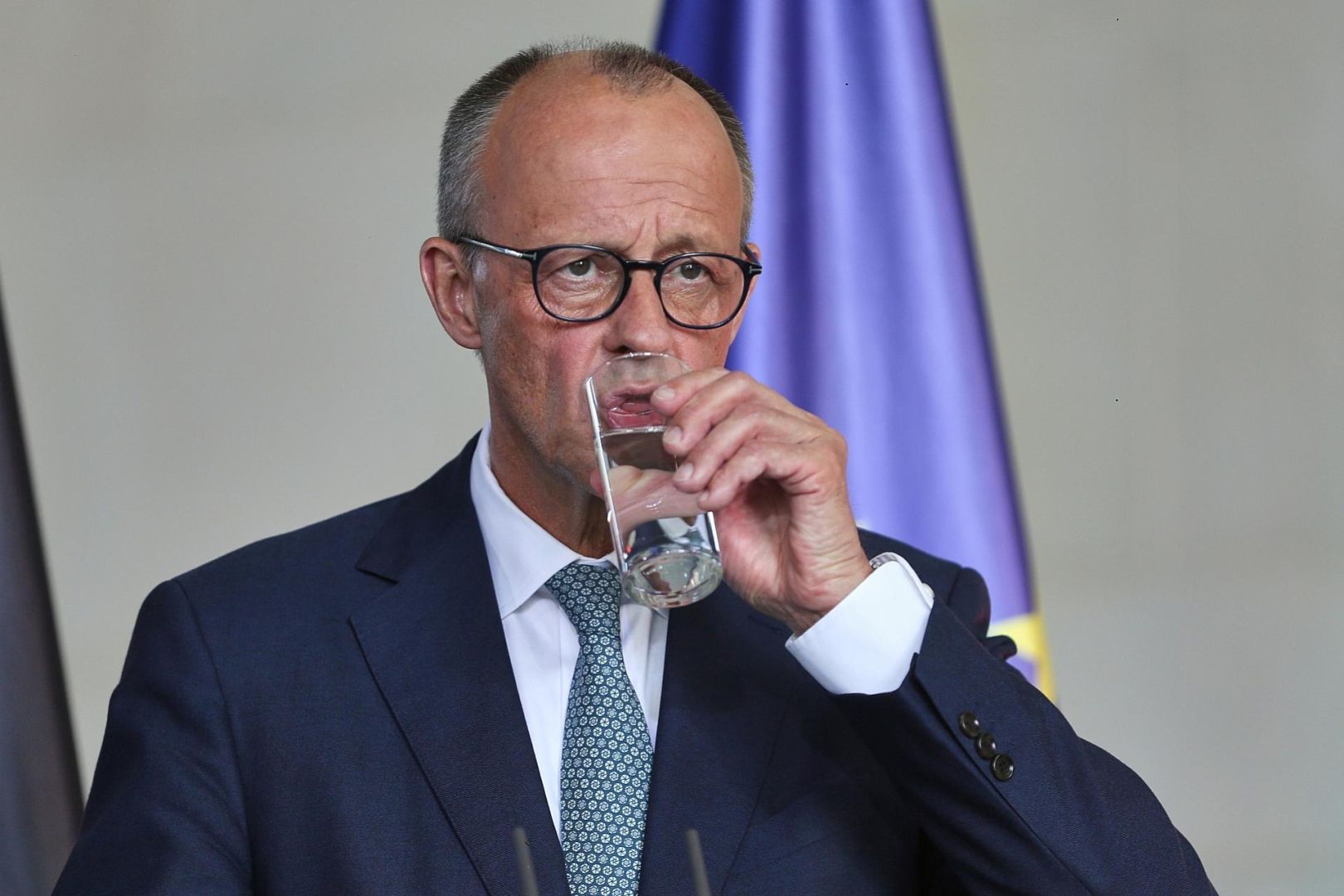 Friedrich Merz trinkt aus einem Glas Wasser - ohne Sprudel (Archiv)
