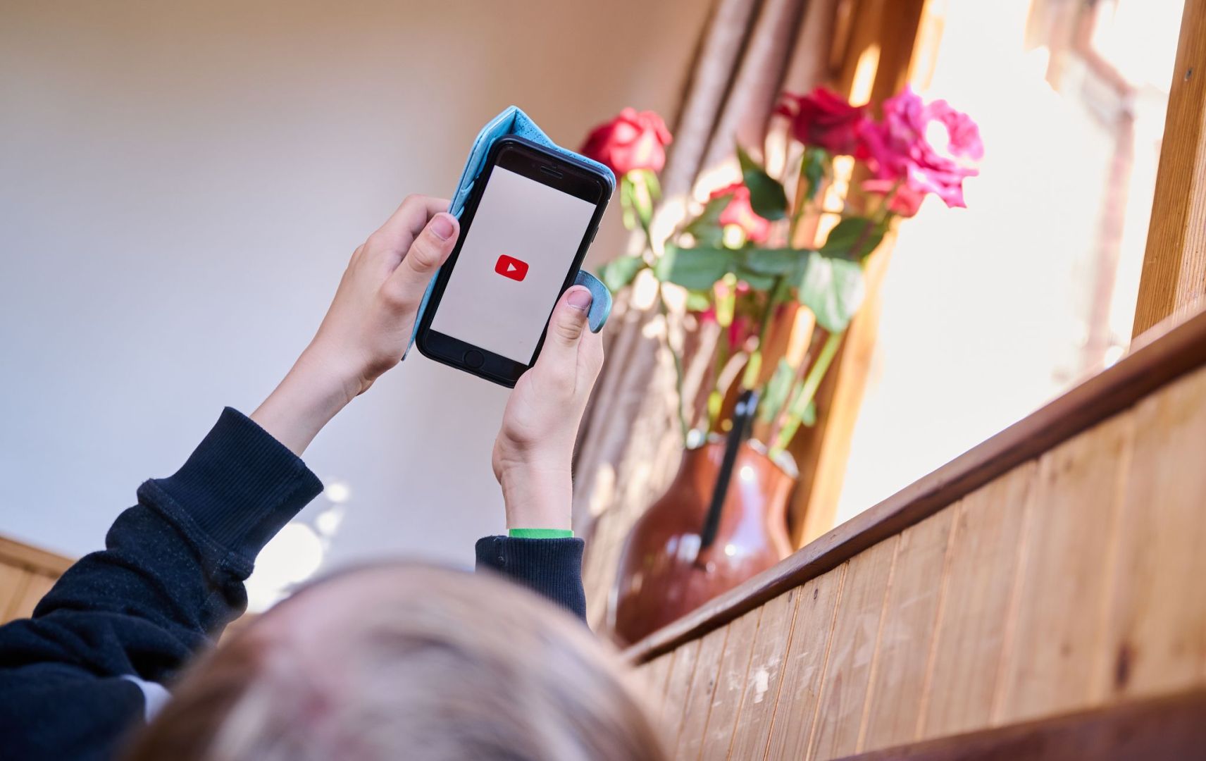 Junge öffnet auf seinem Smartphone die App von YouTube