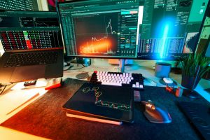 Lebendiges Handels-Setup mit mehreren Bildschirmen, die Kryptowährungsdiagramme und Datenanalysetools anzeigen.
