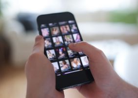 Mann schaut sich Videos auf einem Smartphone an