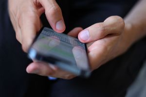 Mann tippt auf einem Smartphone eine WhatsApp Nachricht