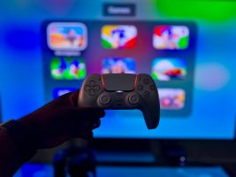 Nahaufnahme eines Gaming-Controllers vor einem leuchtenden Bildschirm in London, England.