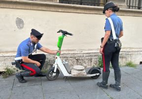 Tourist mit antikem Marmorsockel auf einem E-Scooter